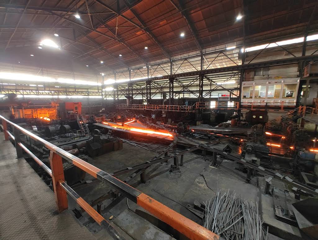 Wide shot of rolling mill processing hot steel
